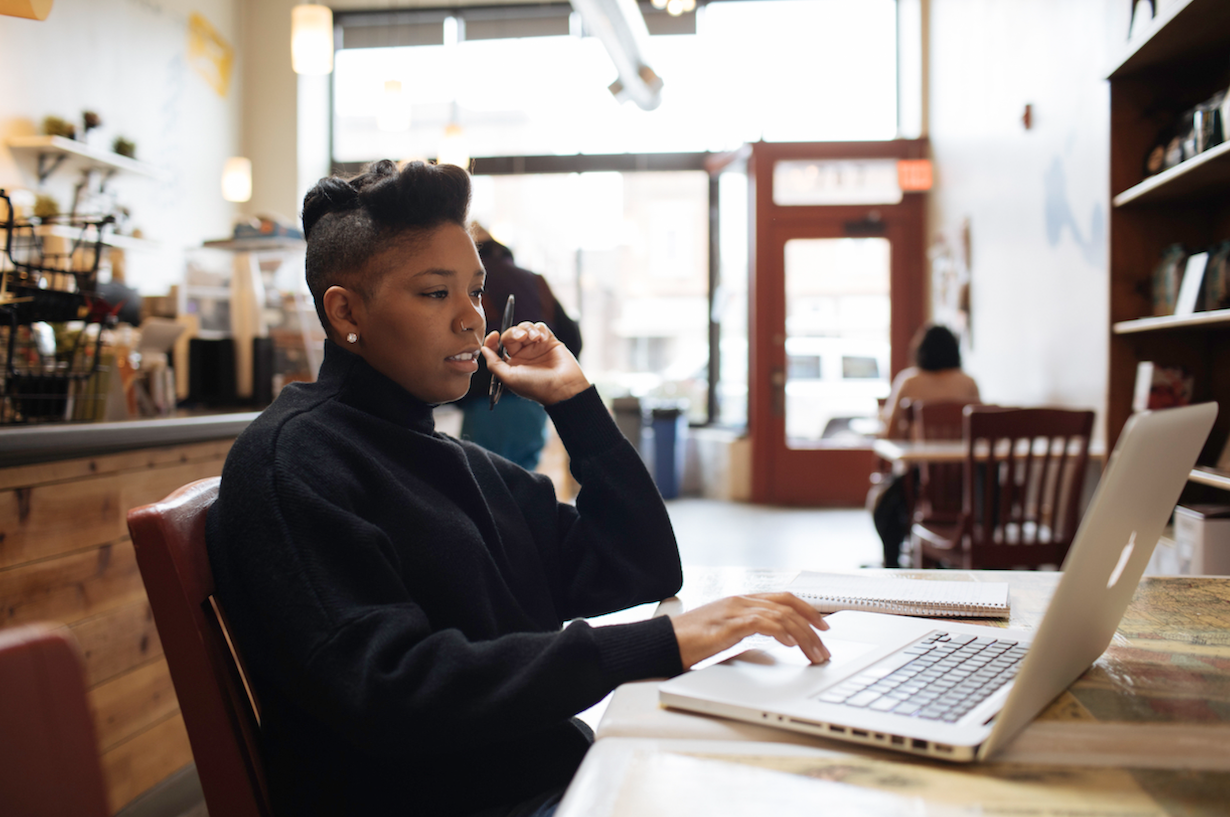 A young entrepreneur at work on her laptop in a coffee shop.